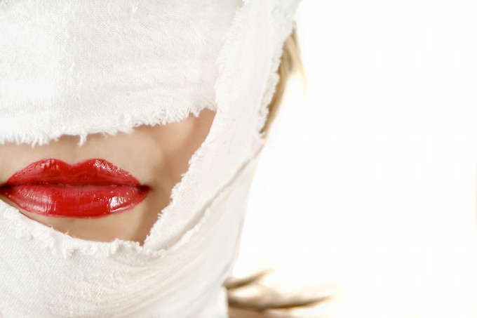交通事故により顔に傷を負い包帯を巻いている女性のイメージ画像